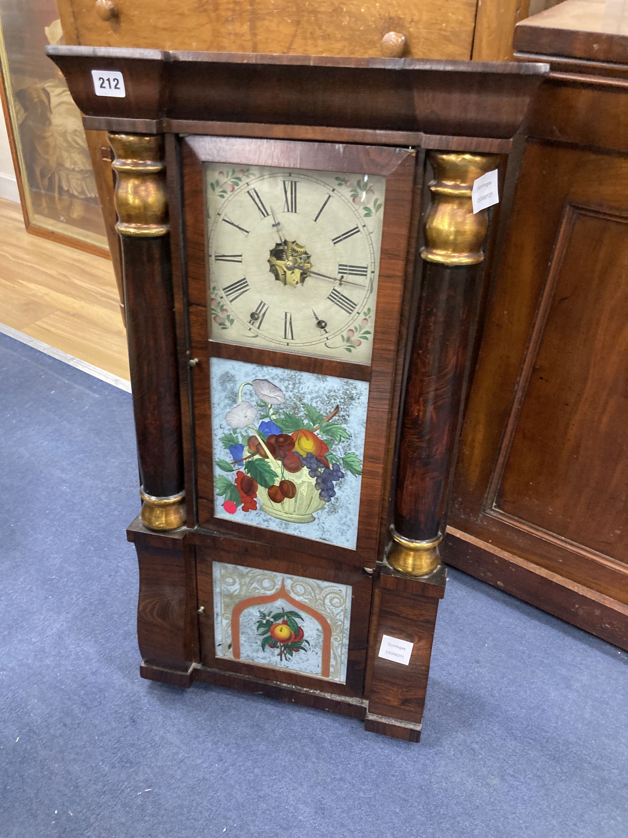 A 19th century American simulated rosewood wall clock, height 84cm, a 19th century inlaid wall clock and a mahogany pedestal cupboard